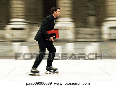 Businessman rollerblading in front of building, blurred. View Large Photo Image Stock Photo - Businessman rollerblading in front of building, blurred.. Fotosearch