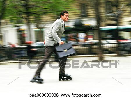 Businessman rollerblading in park, blurred. View Large Photo Image Stock Photo - Businessman rollerblading in park, blurred.. Fotosearch