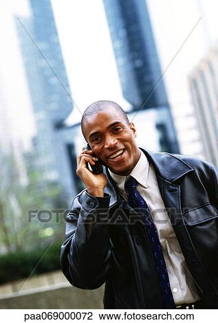 Businessman using cellular phone, in front of skyscraper, portrait. View Large Photo Image Stock Image - Businessman using cellular phone, in front of skyscraper, portrait.. Fotosearch