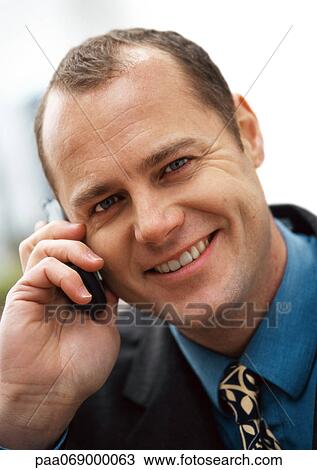 Businessman using cellular phone, smiling at camera, portrait, close-up. View Large Photo Image Stock Image - Businessman using cellular phone, smiling at camera, portrait, close-up.. Fotosearch