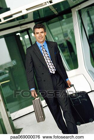 Businessman walking with luggage and briefcase. View Large Photo Image Stock Photograph - Businessman walking with luggage and briefcase.. Fotosearch