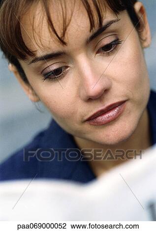 Stock Image - Businesswoman reading, close-up portrait.. Fotosearch
