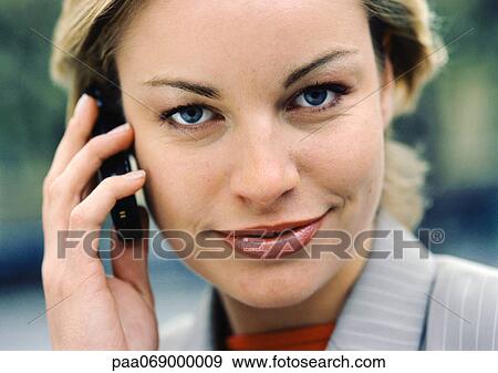 Businesswoman using cellular phone, looking at camera, close-up View Large Photo Image Stock Photo - Businesswoman using cellular phone, looking at camera, close-up. Fotosearch