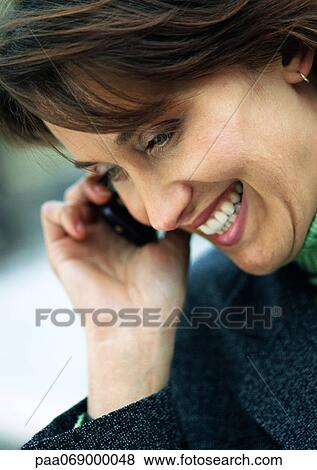 Stock Photo - Businesswoman using cellular phone, laughing and looking down, close-up, portrait.. Fotosearch