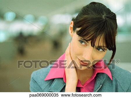 Stock Photography - Businesswoman with hand on neck looking away, close-up. Fotosearch