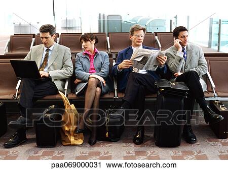 Stock Image - Group of business people sitting in terminal.. Fotosearch