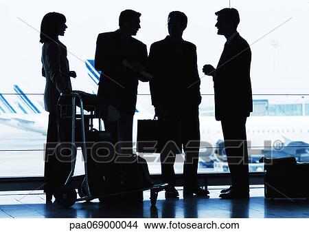 Group of business people standing inside airport, silhouette. View Large Photo Image Picture - Group of business people standing inside airport, silhouette.. Fotosearch