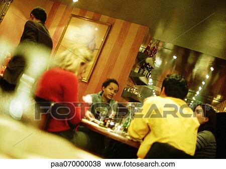 Group of young people sitting in restaurant View Large Photo Image Stock Photo - Group of young people sitting in restaurant. Fotosearch
