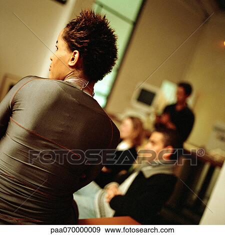 Stock Photo - Group of young people, woman in foreground, rear view.. Fotosearch