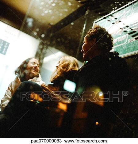 Three young women sitting in bus shelter at night, laughing View Large Photo Image Stock Image - Three young women sitting in bus shelter at night, laughing. Fotosearch