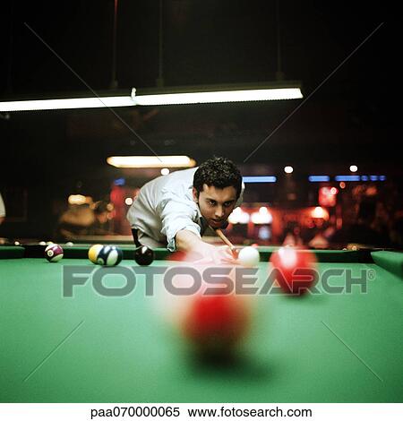 Young man shooting pool, billiard ball blurred in foreground View Large Photo Image Stock Photography - Young man shooting pool, billiard ball blurred in foreground. Fotosearch