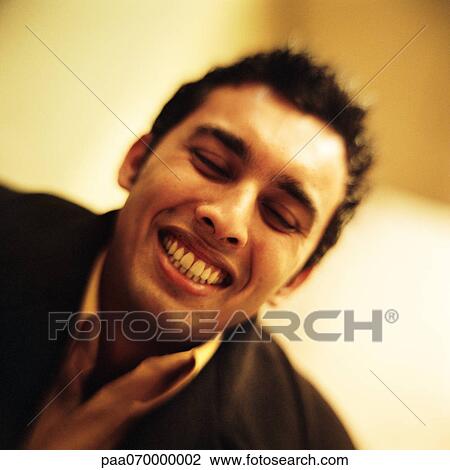 Stock Image - Young man smiling, close-up, portrait. Fotosearch