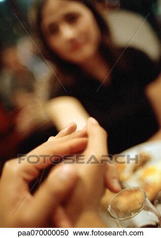 Young man's hands in foreground, woman blurred in background View Large Photo Image Stock Image - Young man's hands in foreground, woman blurred in background. Fotosearch
