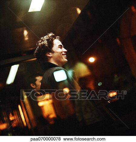 Young men standing in bus shelter at night View Large Photo Image Stock Photo - Young men standing in bus shelter at night. Fotosearch