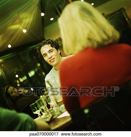 Young people sitting at table, talking View Large Photo Image Stock Photo - Young people sitting at table, talking. Fotosearch
