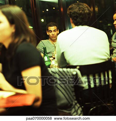 Stock Photo - Young people sitting in bar. Fotosearch