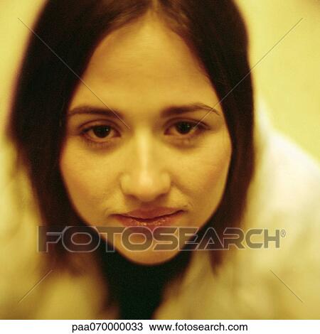 Stock Image - Young woman looking at camera, close-up, portrait.. Fotosearch