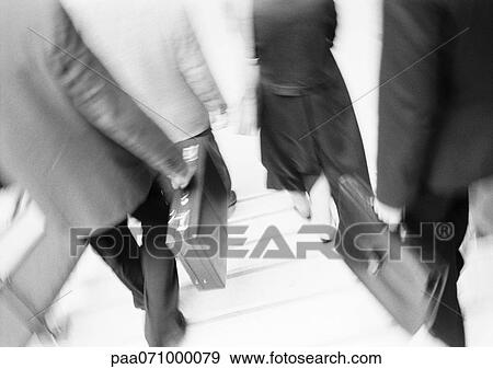 Stock Photo - Business people walking down steps, lower section, blurred, b&w.. Fotosearch