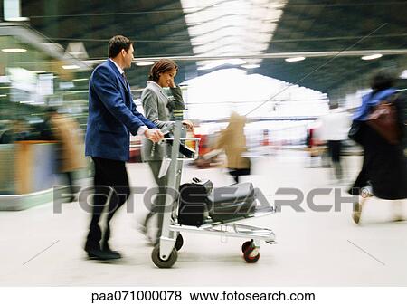 Businessman and businesswoman walking together with luggage through station, blurred. View Large Photo Image Stock Photo - Businessman and businesswoman walking together with luggage through station, blurred.. Fotosearch