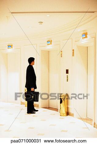 Stock Image - Businessman waiting for elevator.. Fotosearch