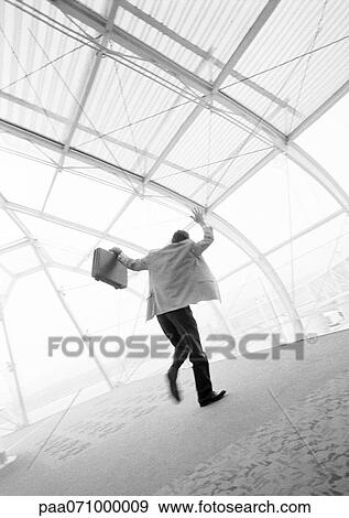 Businessman waving hand and briefcase, rear view, blurred b&w. View Large Photo Image Stock Photo - Businessman waving hand and briefcase, rear view, blurred b&w.. Fotosearch
