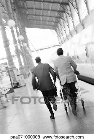 Businessmen hurrying on train platform, blurred, rear view. View Large Photo Image Stock Photo - Businessmen hurrying on train platform, blurred, rear view.. Fotosearch