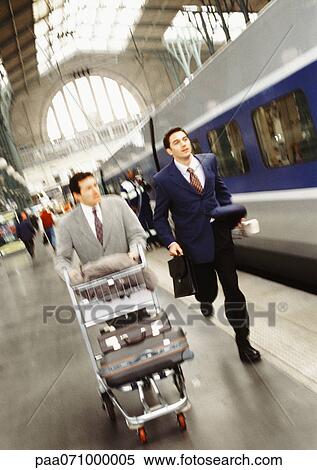 Stock Photography - Businessmen running on train platform, blurred.. Fotosearch