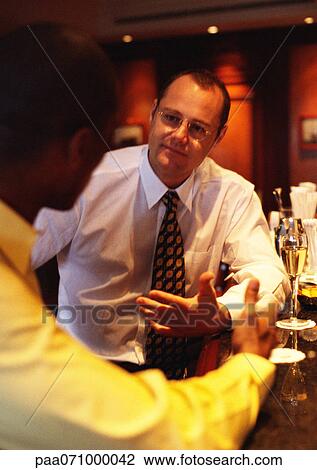 Businessmen sitting at bar talking. View Large Photo Image Stock Image - Businessmen sitting at bar talking.. Fotosearch