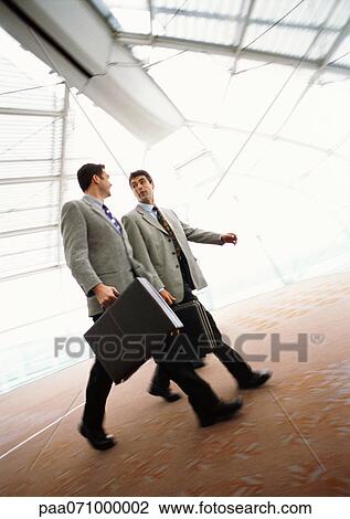 Businessmen walking together with briefcases, indoors. View Large Photo Image Stock Image - Businessmen walking together with briefcases, indoors.. Fotosearch