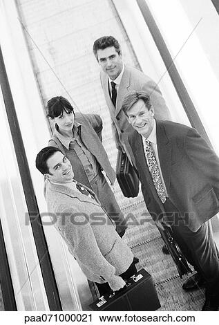 Group of business people on moving walkway, looking at camera, high angle view, b&w View Large Photo Image Stock Image - Group of business people on moving walkway, looking at camera, high angle view, b&w. Fotosearch
