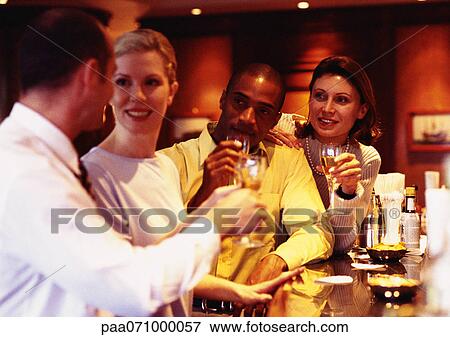 Stock Photo - Group of business people raising glasses at bar. Fotosearch