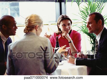 Group of business people sitting at table, eating, close up. View Large Photo Image Picture - Group of business people sitting at table, eating, close up.. Fotosearch