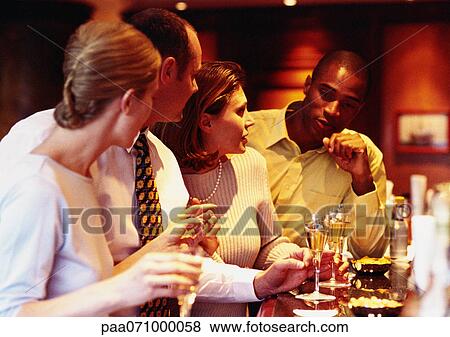 Stock Photo - Group of business people socializing at bar.. Fotosearch