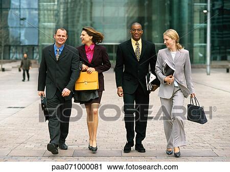 Group of business people walking together outside, full length, front view View Large Photo Image Stock Image - Group of business people walking together outside, full length, front view. Fotosearch