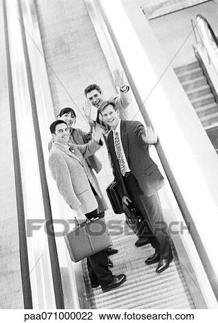 Stock Image - Group of business people waving at camera, blurred, b&w.. Fotosearch