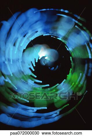 Clipart - Spiraling light effect, blues and greens, black background. Fotosearch
