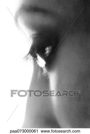 Stock Image - Partial view of woman's face, eye looking down, blurred, black and white.. Fotosearch