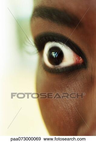 Stock Photo - Partial view of woman's face, eye wide open, blurred.. Fotosearch