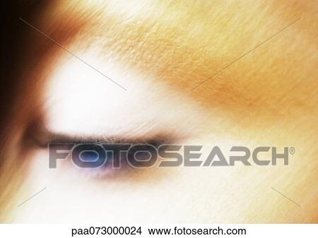 Picture - Woman's blue eye looking down, blurred close up.. Fotosearch