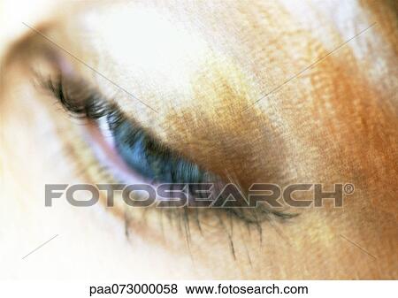 Stock Photo - Woman's blue eye looking down, blurred close up.. Fotosearch