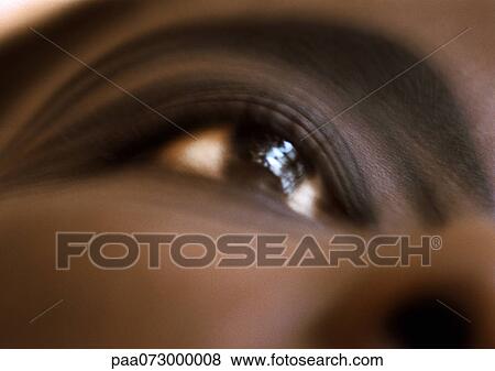 Stock Photo - Woman's brown eye, low angle view, blurred close up.. Fotosearch