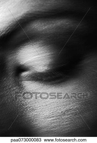 Stock Image - Woman's eye closed, close up, black and white, blurred. Fotosearch