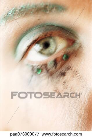 Stock Photo - Woman's eye with make-up on eyelid and under eye, close-up, blurred.. Fotosearch