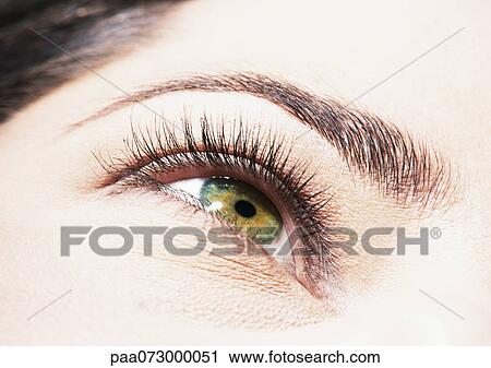 Stock Image - Woman's green eye, low angle view, close up.. Fotosearch
