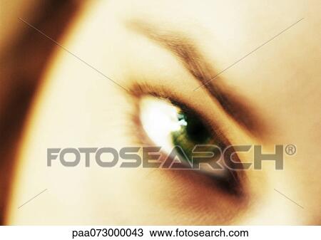 Stock Image - Woman's hazel eye, front view, blurred.. Fotosearch