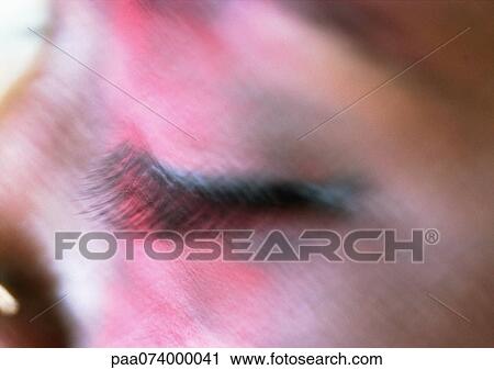 Stock Image - Woman's closed eye with make-up of face, close-up, blurry.. Fotosearch