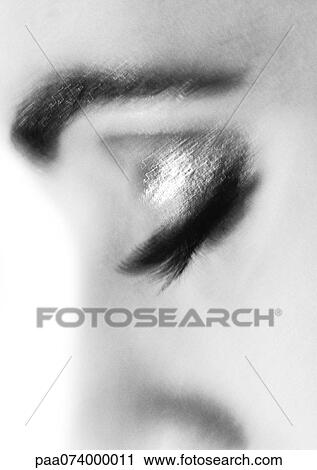 Stock Image - Woman's closed eye with make-up, blurry, close-up, black and white.. Fotosearch