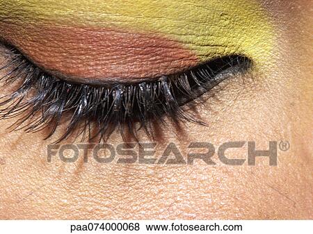 Woman's closed eye with yellow and orange eye shadow, extreme close-up View Large Photo Image Stock Photo - Woman's closed eye with yellow and orange eye shadow, extreme close-up. Fotosearch