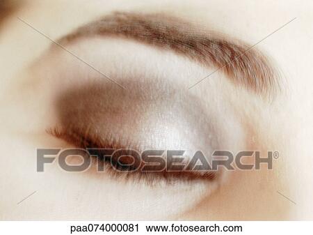 Stock Image - Woman's closed, made-up eye, close-up, blurry.. Fotosearch