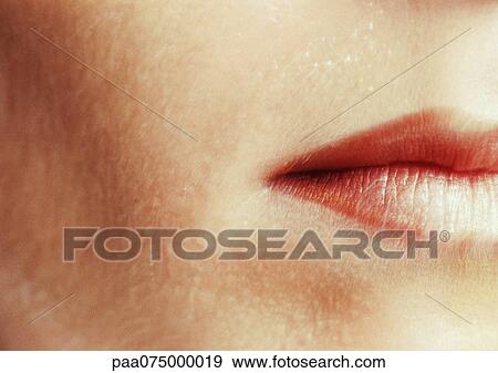 Stock Photo - Woman wearing lipstick, close up of cropped mouth.. Fotosearch